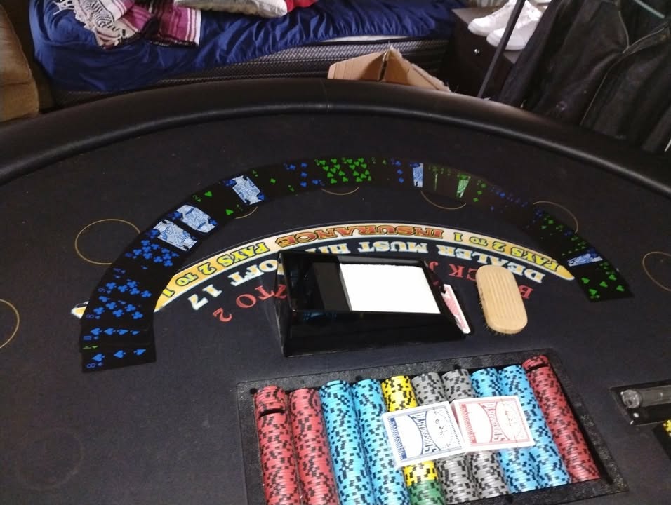 Blackjack table arranged with playing cards, chips, and game equipment