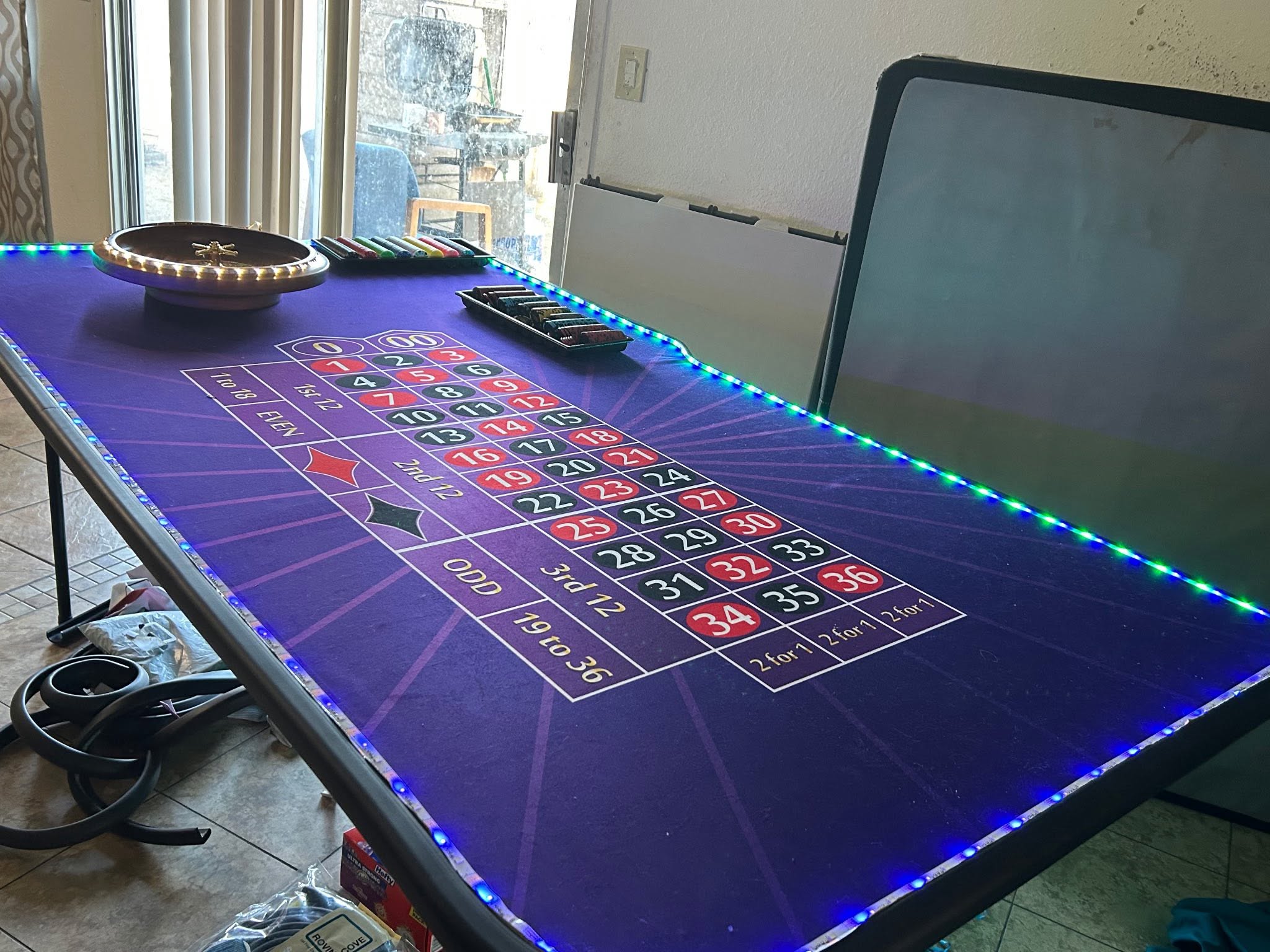 Purple roulette table with an illuminated edge and roulette wheel