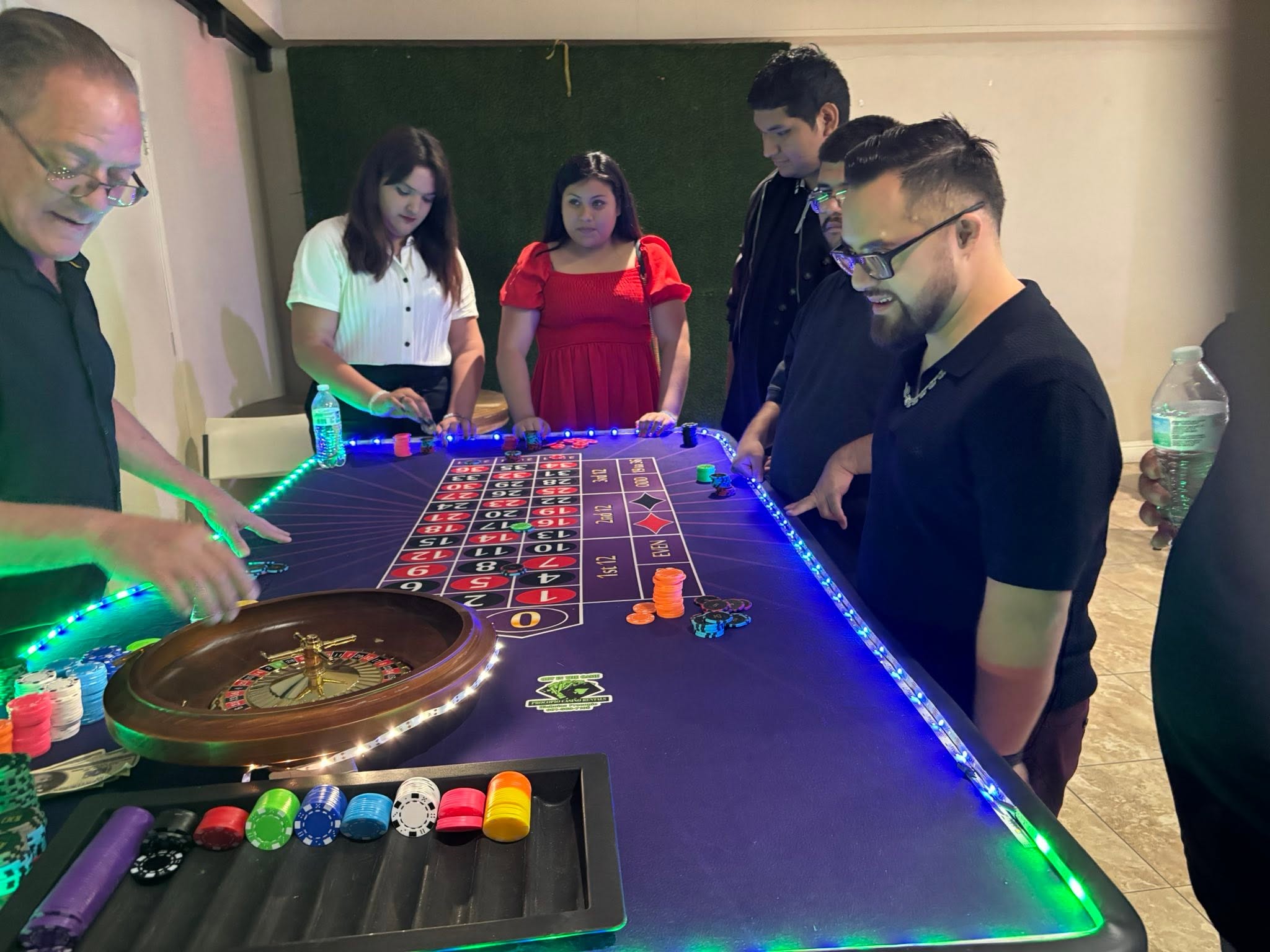 Guests gathered around a roulette table at a Procopio Casino Rentals game night